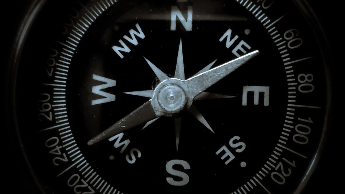 Close-up of a compass needle pointing north, symbolizing guidance and direction.